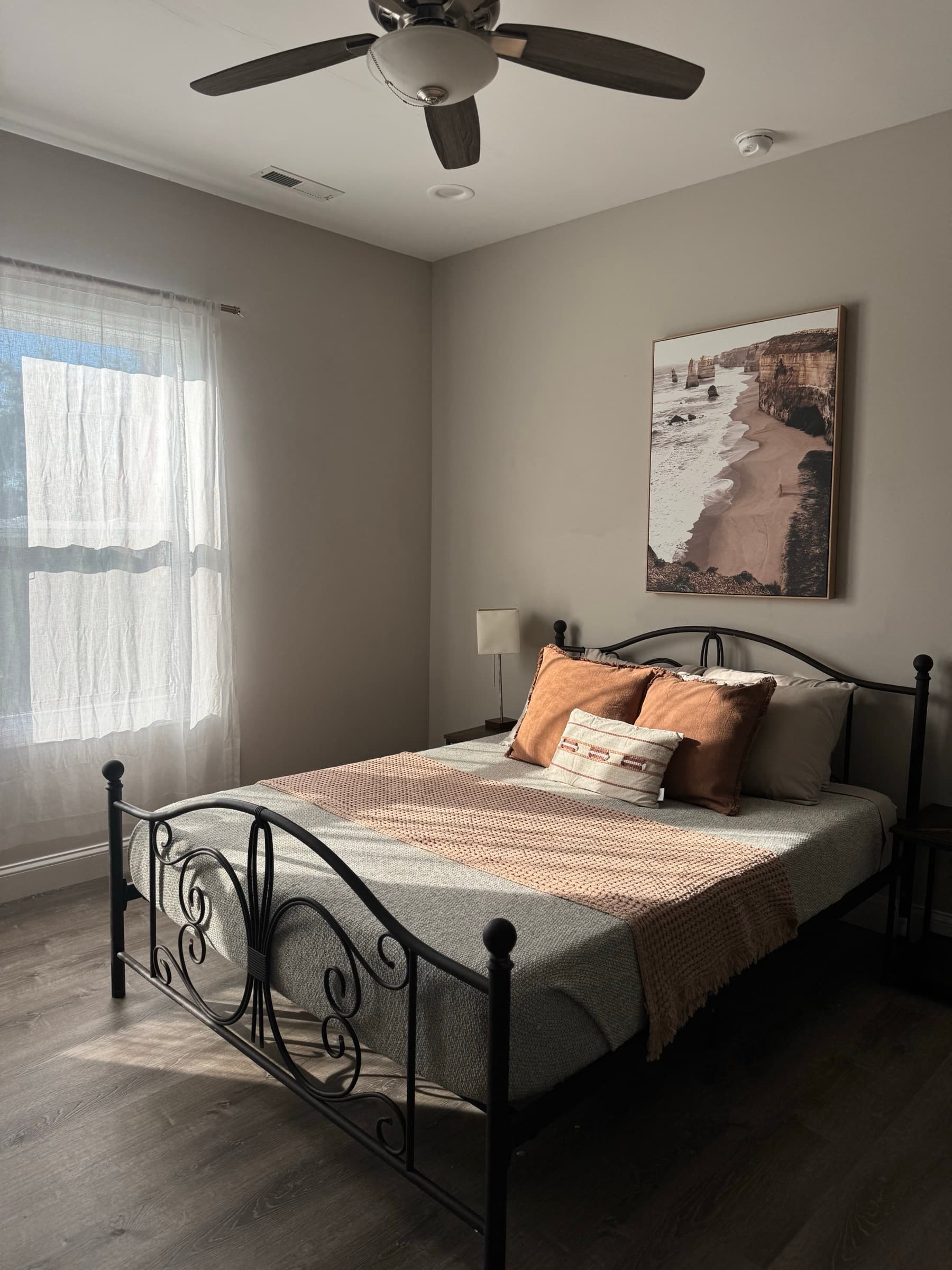 Bright bedroom with iron bed frame and neatly made bedding