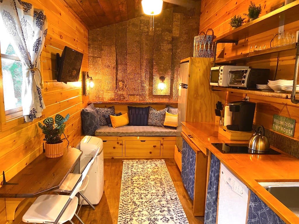 Warm wood living area with kitchenette, dining nook, and bark-wall seating